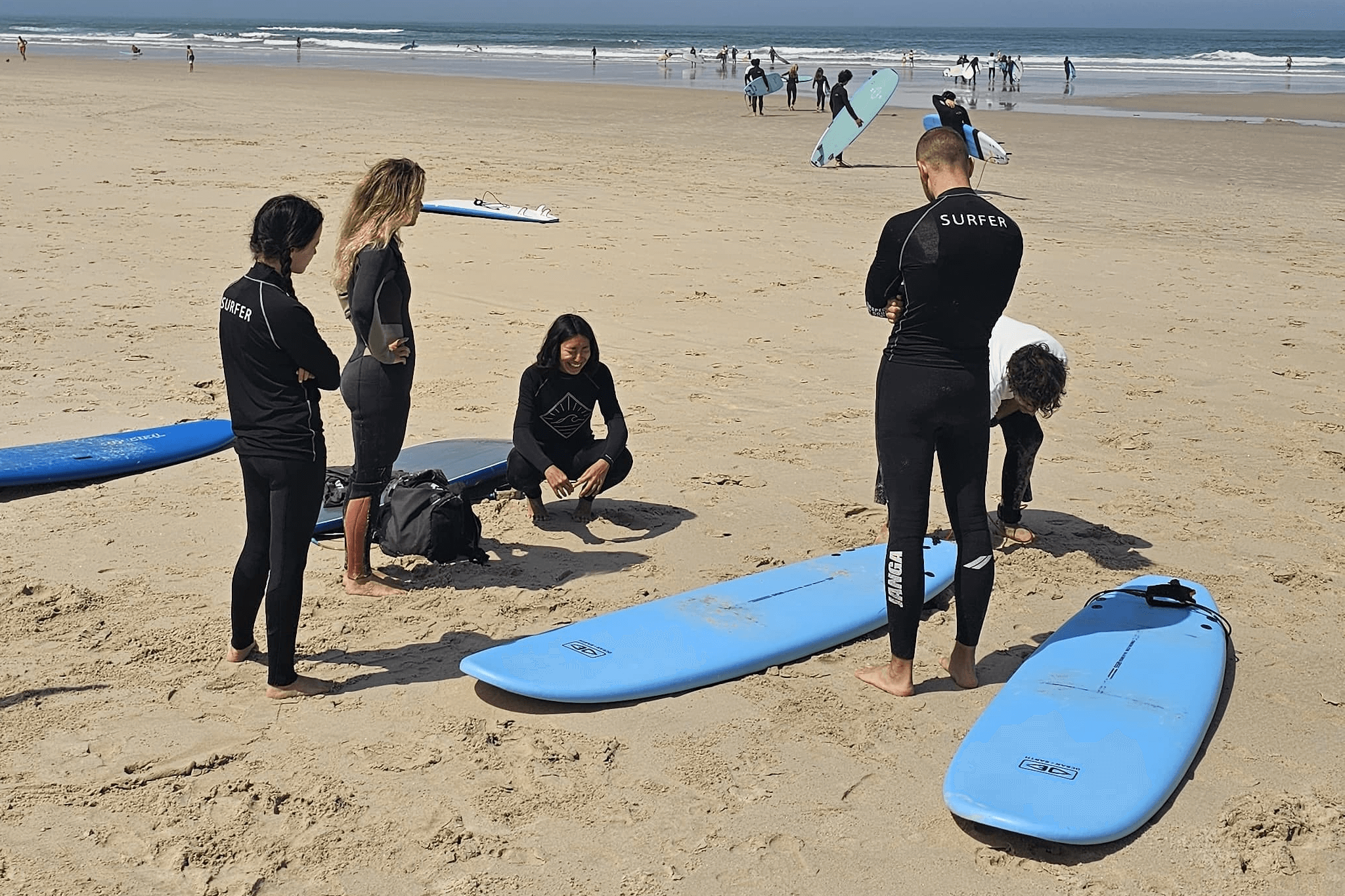 Alunos a aprender a levantar-se nas pranchas durante uma sessão na Praia do Cabedelo, Figueira da Foz