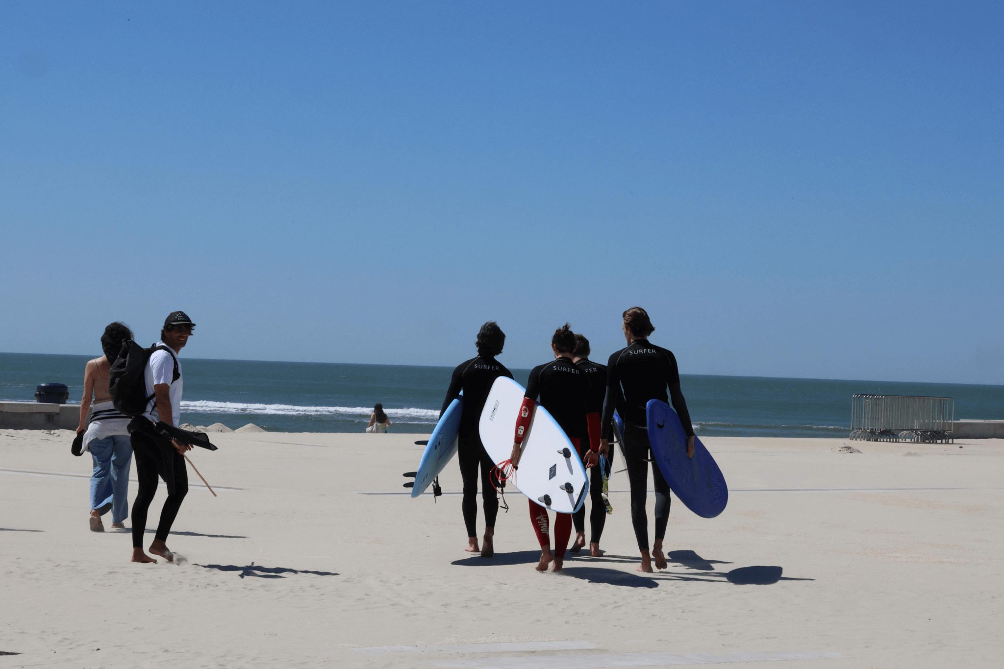 Alunos a aprender a levantar-se nas pranchas durante uma sessão na Praia do Cabedelo, Figueira da Foz