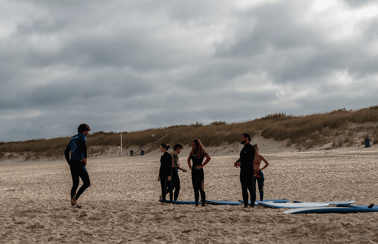 Alunos a aprender a levantar-se nas pranchas durante uma sessão na Praia do Cabedelo, Figueira da Foz