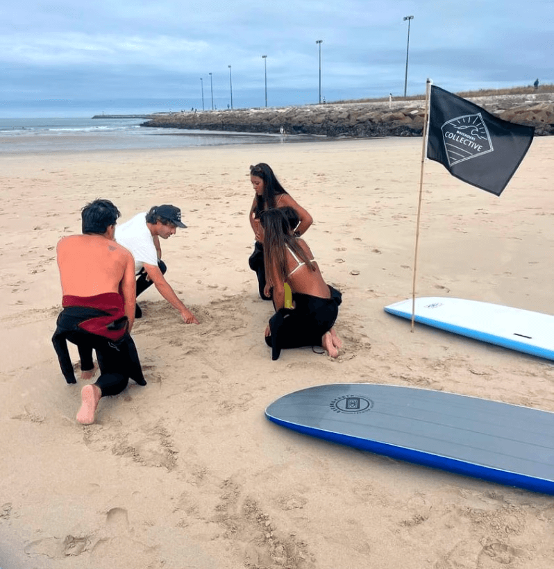 Instrutor de surf a guiar os alunos para dentro de água na escola de surf da Figueira da Foz